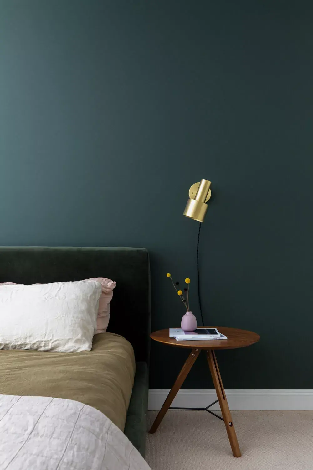 bedroom with deep teal walls, bed, and nightstand