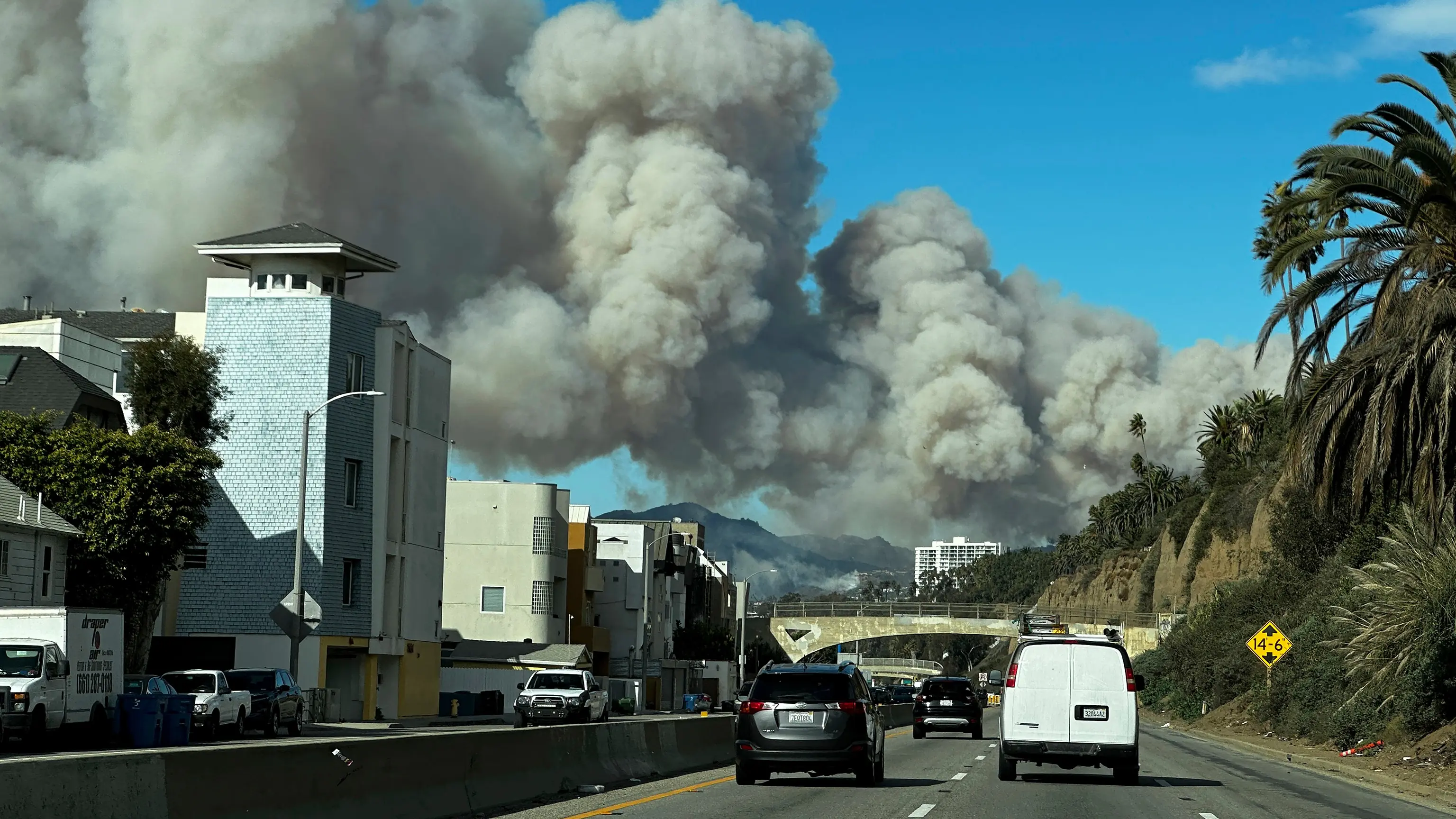 Heavy smoke from a brush fire in the Pacific Palisades rises over the Pacific Coast Highway in Santa Monica, Calif., on Tuesday, Jan. 7, 2025.