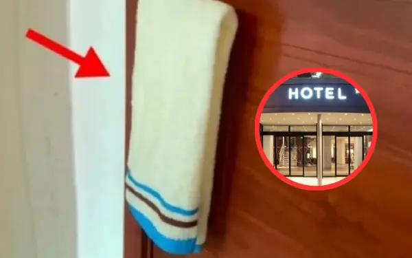 Why should wet towels be hung on the door handle in hotels?
