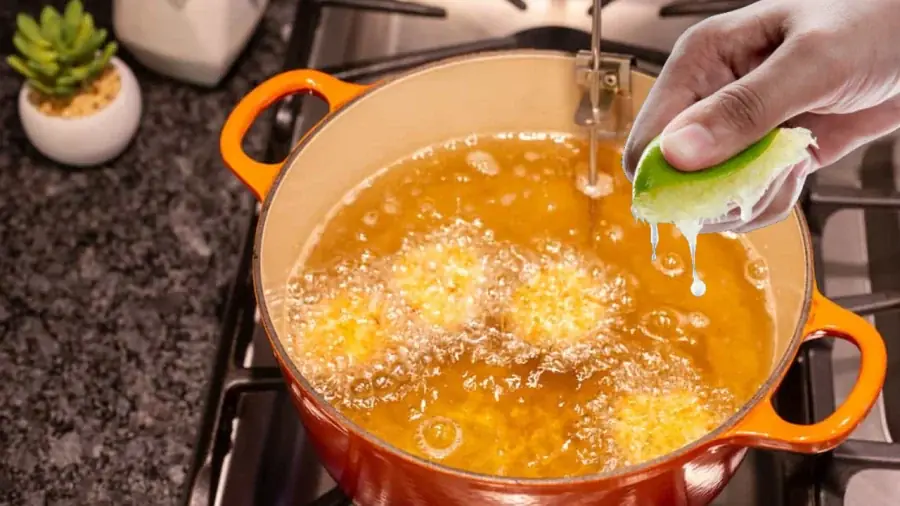 What is the effect of squeezing lemon juice into the frying oil before frying?