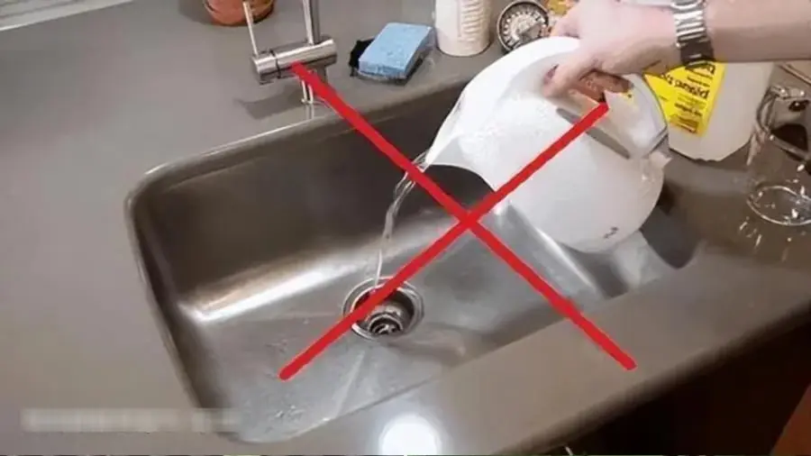 Pouring Hot Water into the Kitchen Sink