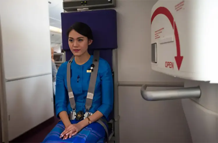 Why cabin crew place their hands under their legs during takeoff?