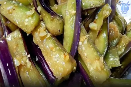 A glossy bowl of cooked eggplant, sliced into tender strips and coated with sauce, looks like comfort food at its best.