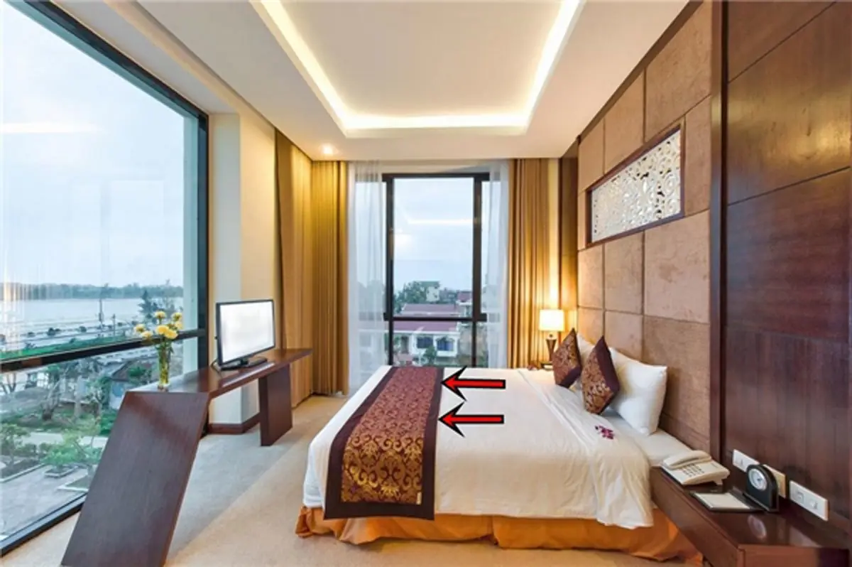 Why do hotels place a fabric strip at the foot of the bed?