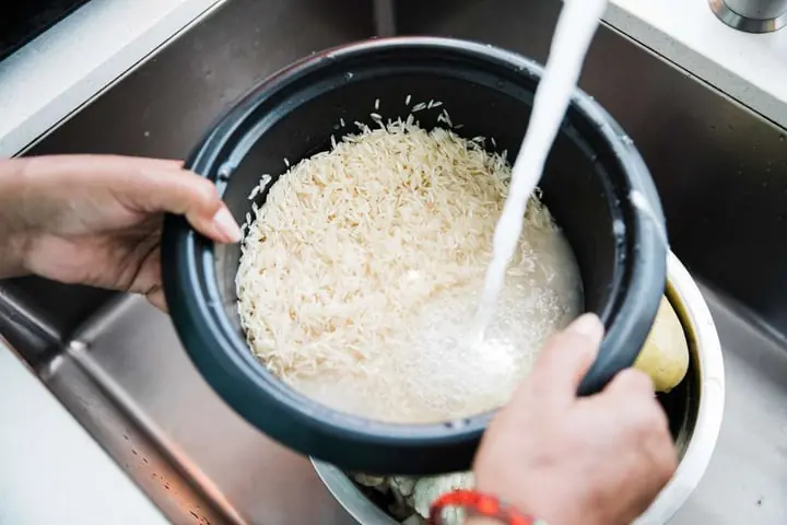 Why washing rice in the rice cooker bowl is not recommended?